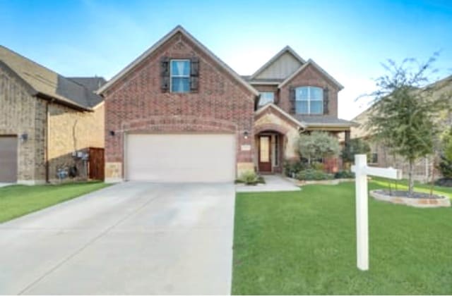view of front of house featuring concrete driveway, a front yard, brick siding, and a garage