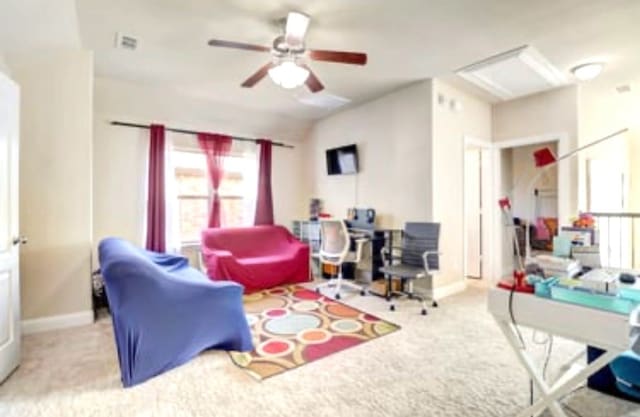 carpeted living area with a ceiling fan, baseboards, lofted ceiling, and a healthy amount of sunlight
