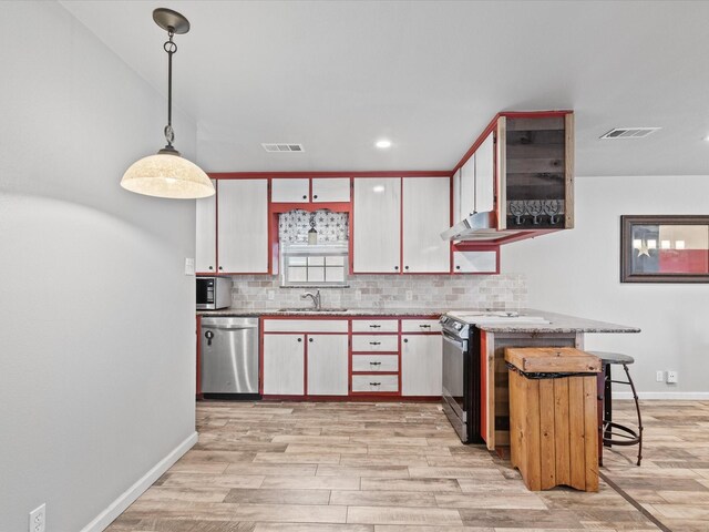 kitchen featuring visible vents, a sink, tasteful backsplash, and stainless steel appliances