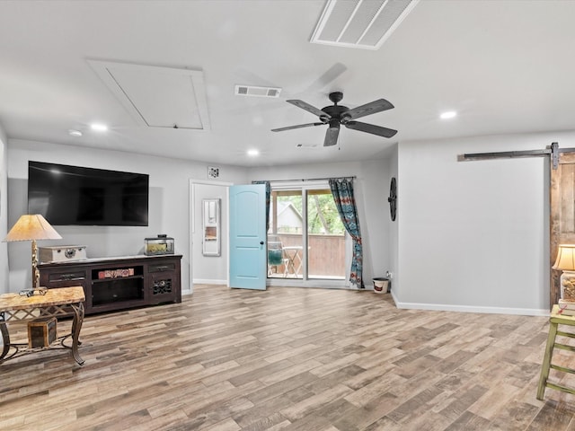 living room with a barn door, attic access, recessed lighting, baseboards, and visible vents