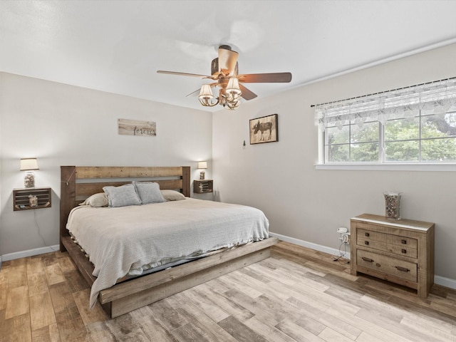 bedroom with baseboards, ceiling fan, and light wood finished floors