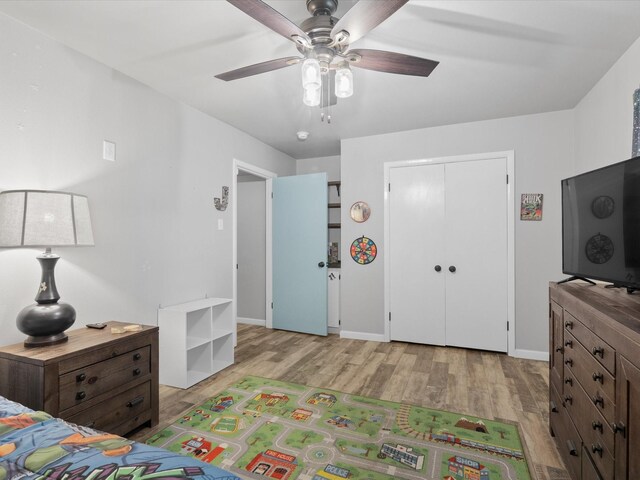 bedroom with baseboards, a ceiling fan, wood finished floors, and a closet