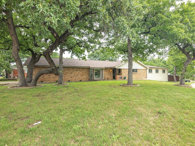 ranch-style home featuring a front yard and brick siding