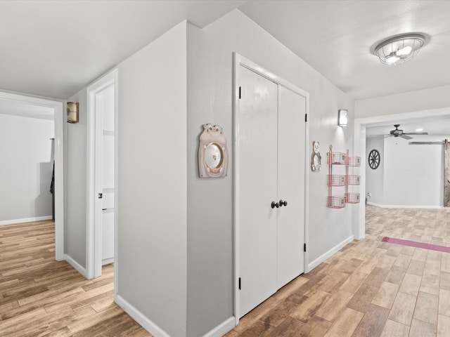hallway featuring baseboards and light wood-style flooring
