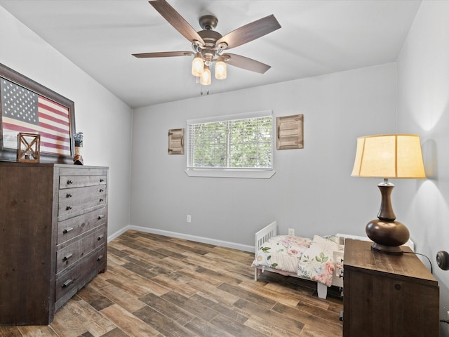 sitting room with baseboards, ceiling fan, and wood finished floors