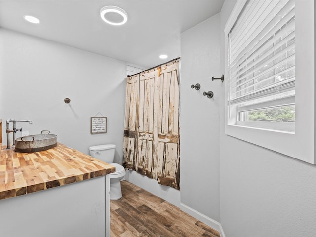 full bath featuring a shower with curtain, wood finished floors, vanity, toilet, and recessed lighting