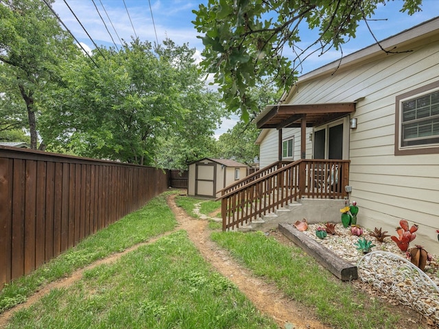 view of yard with a storage shed, an outbuilding, and a fenced backyard