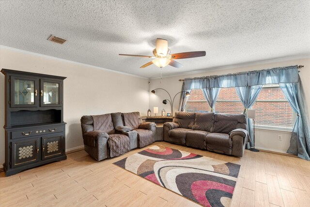 living area featuring ceiling fan, crown molding, visible vents, and light wood-style flooring