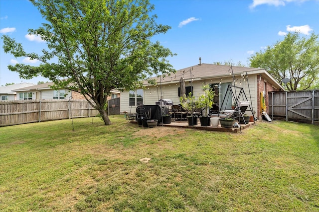 rear view of property featuring a lawn and a fenced backyard