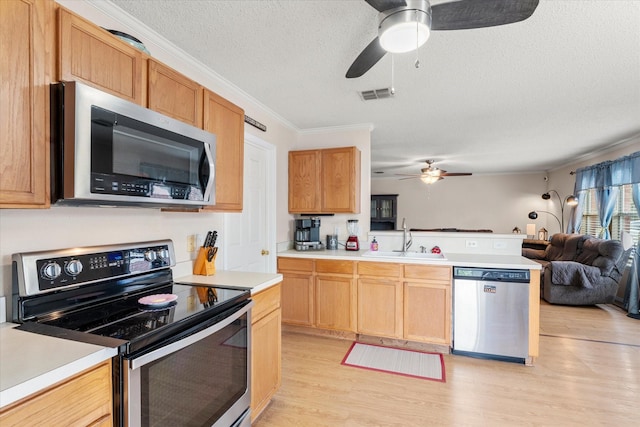 kitchen with stainless steel appliances, a sink, open floor plan, visible vents, and ceiling fan