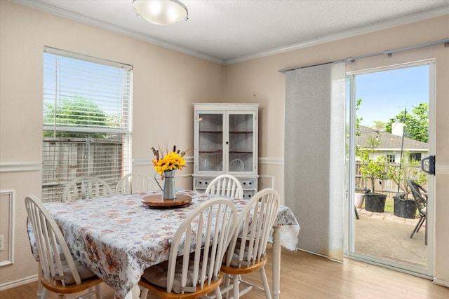 dining space with light wood-style flooring and crown molding