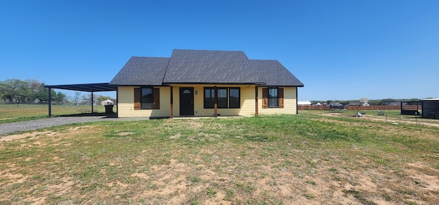 bungalow-style home featuring a front lawn, a carport, driveway, fence, and a shingled roof