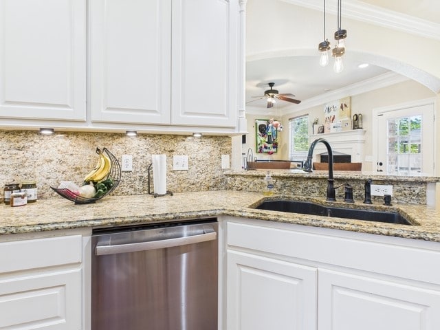 118 Chickadee Dr, Whitehouse, TX 75791 - kitchen with stainless steel dishwasher, a sink, arched walkways, backsplash, and ornamental molding