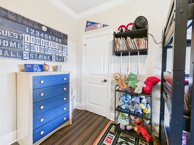 118 Chickadee Dr, Whitehouse, TX 75791 - game room with dark wood finished floors, baseboards, and ornamental molding