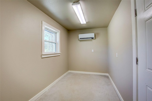 spare room with baseboards and a wall mounted air conditioner