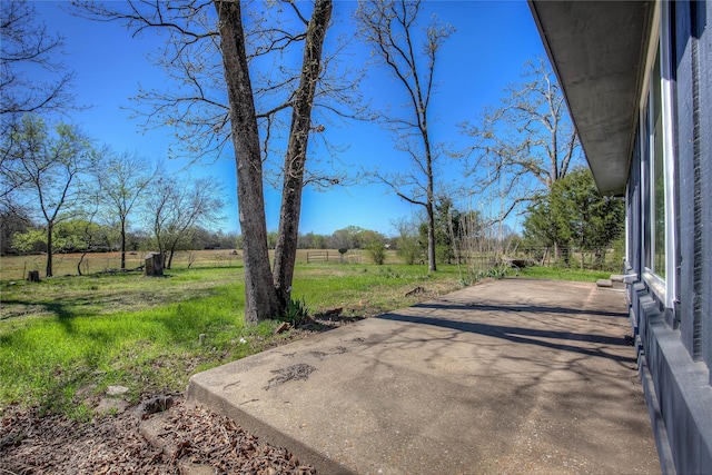 view of yard with a patio area, a rural view, and driveway