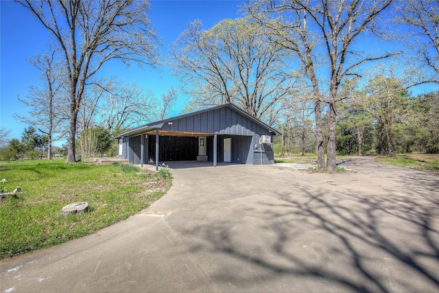 view of side of property featuring driveway, a yard, and board and batten siding