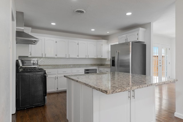 7024 Irongate Ln, Dallas, TX 75214 - kitchen featuring stove, stainless steel refrigerator with ice dispenser, wall chimney exhaust hood, dark wood-style floors, and white cabinets