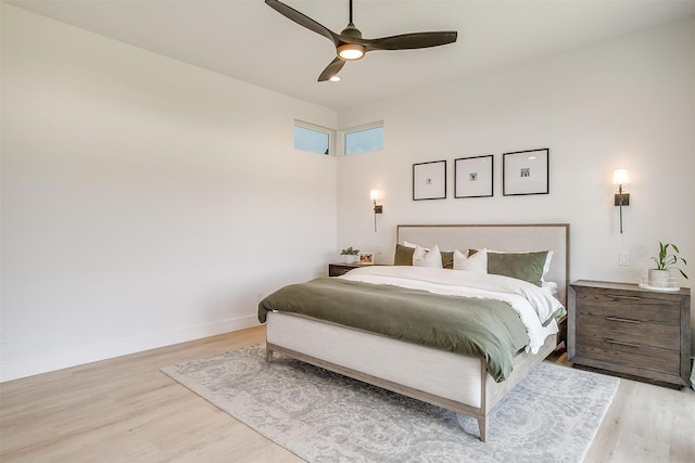 bedroom featuring a ceiling fan, baseboards, and light wood-style floors