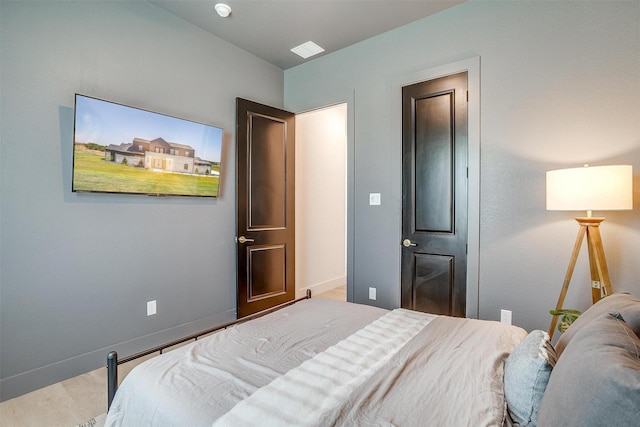 bedroom with wood finished floors and baseboards