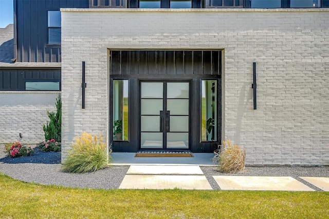 property entrance with brick siding and board and batten siding