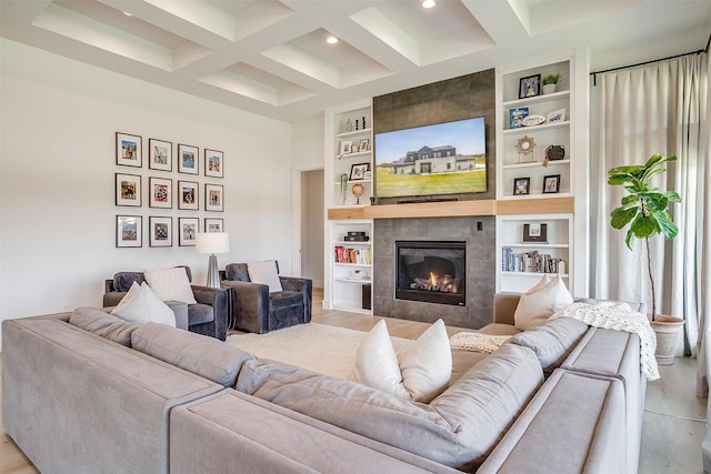 living room with recessed lighting, built in shelves, beamed ceiling, wood finished floors, and a tile fireplace