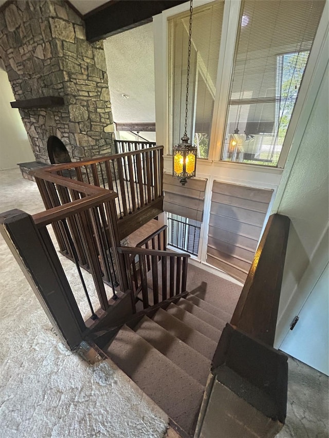 stairs featuring an inviting chandelier and beam ceiling