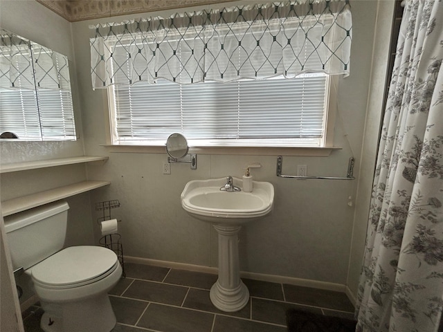 full bath with tile patterned floors, baseboards, curtained shower, and toilet