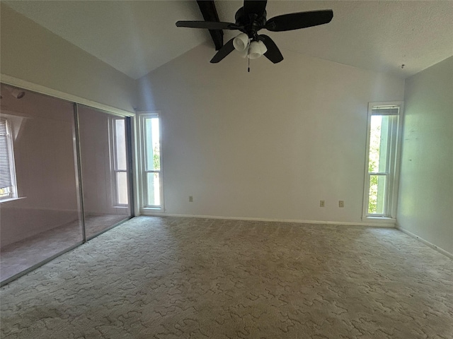 interior space featuring lofted ceiling, carpet, and multiple windows