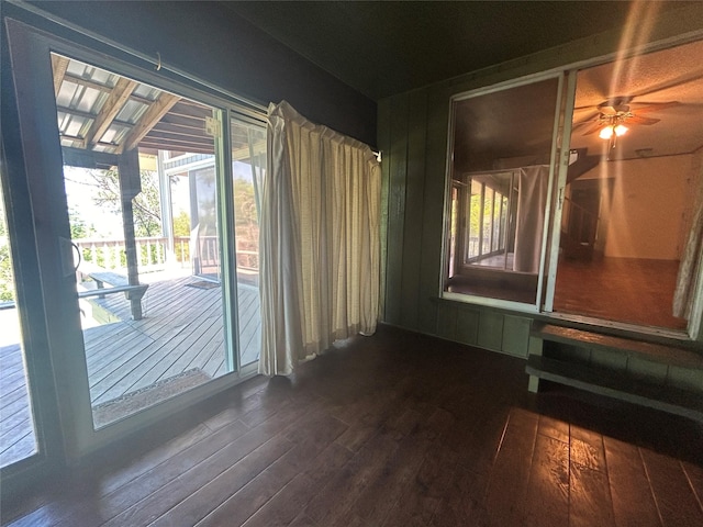 empty room with dark wood-type flooring and a ceiling fan