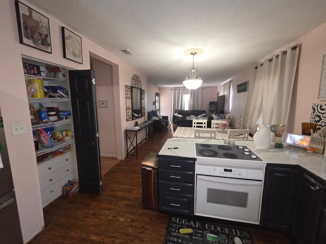 kitchen with open floor plan, oven, black electric cooktop, a peninsula, and dark wood-style floors