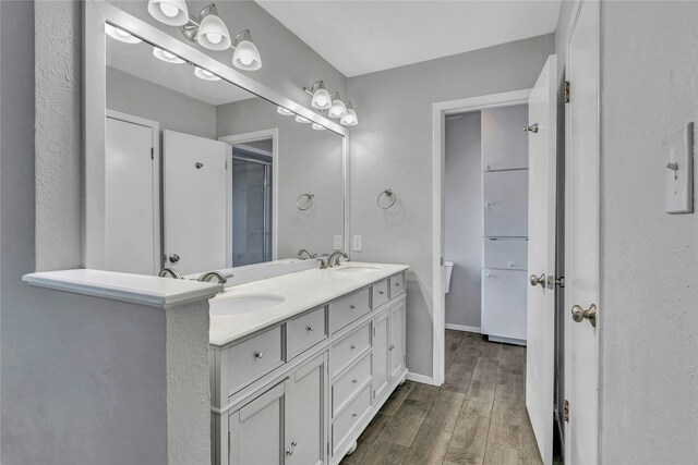 4225 Dawn Dr, Benbrook, TX 76116 - bathroom featuring baseboards, wood finished floors, a sink, and double vanity