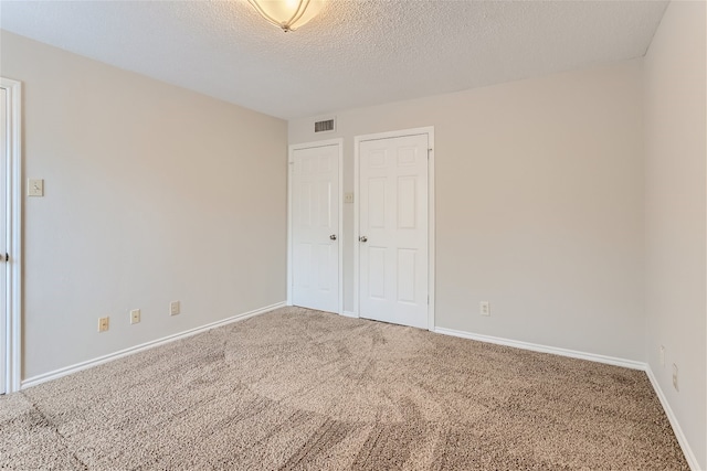 unfurnished bedroom with baseboards, carpet flooring, and a textured ceiling
