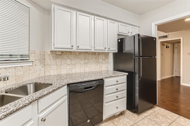 kitchen with white cabinets, backsplash, and black appliances