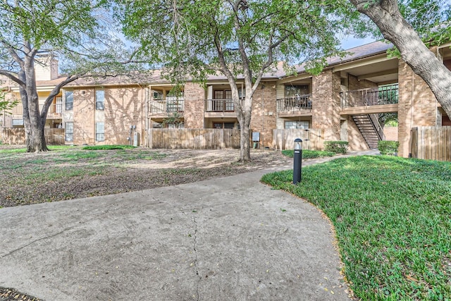 view of property's community with fence and stairs