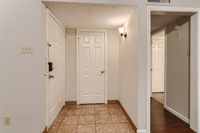 hall featuring visible vents and baseboards