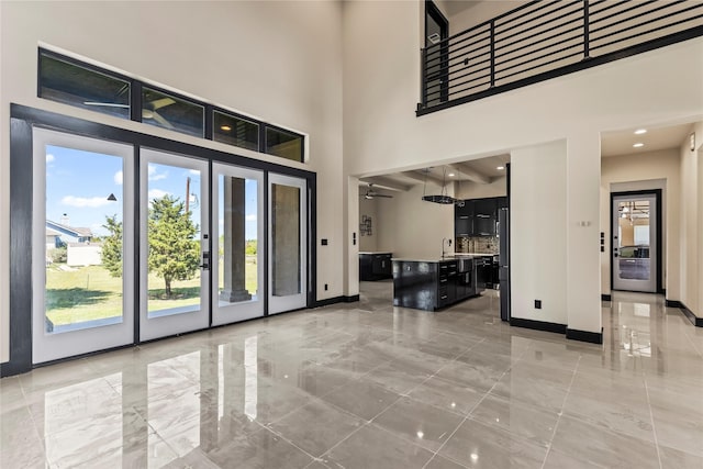 foyer with marble finish floor, baseboards, and plenty of natural light