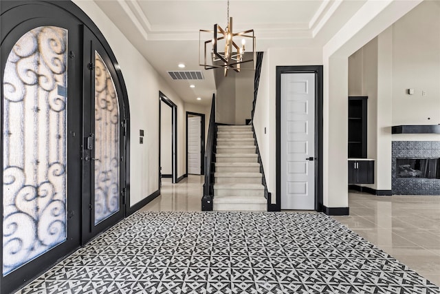 tiled foyer entrance featuring french doors, baseboards, visible vents, an inviting chandelier, and stairway