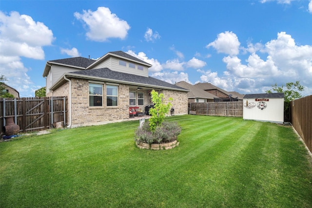 503 Saddle Club Way, Princeton, TX 75407 - rear view of property with a storage shed, a lawn, a fenced backyard, an outdoor structure, and brick siding