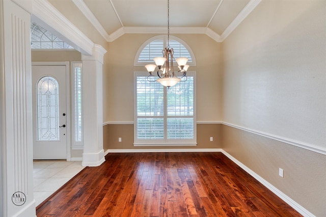foyer entrance with an inviting chandelier, baseboards, wood-type flooring, lofted ceiling, and decorative columns