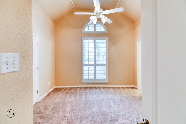 carpeted empty room featuring ceiling fan, lofted ceiling, and baseboards
