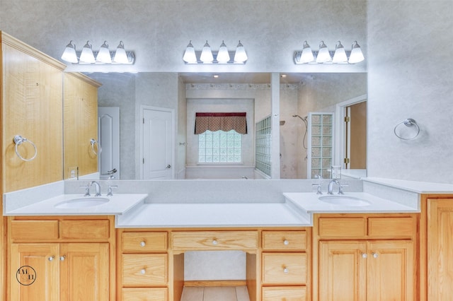 bathroom with a sink, double vanity, and a tile shower