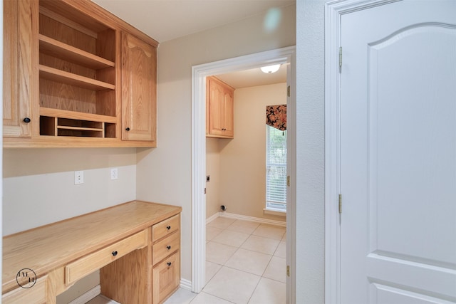 interior space with light brown cabinets, open shelves, light tile patterned flooring, light countertops, and baseboards