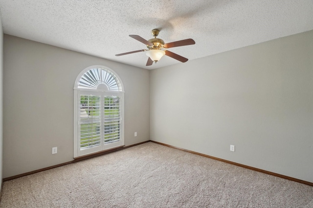spare room with baseboards, carpet floors, a textured ceiling, and ceiling fan