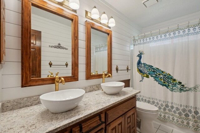 bathroom with tile patterned floors, visible vents, a sink, and double vanity