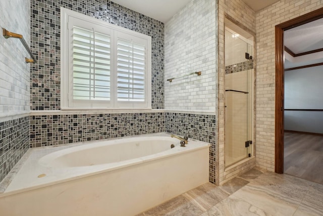 full bathroom featuring tile walls, a garden tub, and a stall shower