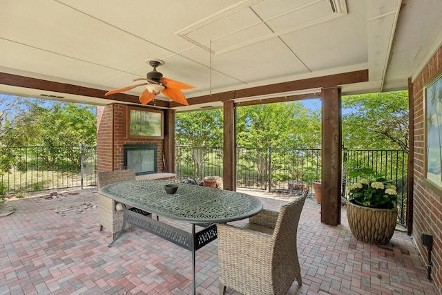 view of patio / terrace with a ceiling fan, an outdoor brick fireplace, and fence