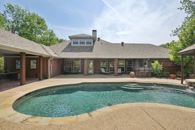 outdoor pool with fence and a patio