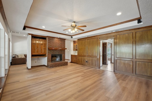 unfurnished living room featuring a ceiling fan, a tray ceiling, visible vents, and light wood-style flooring
