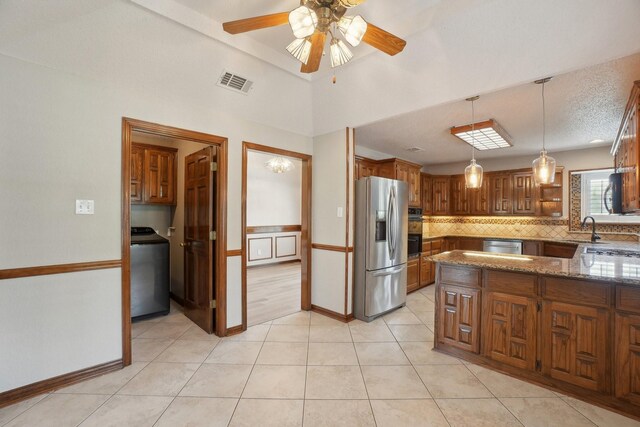 kitchen featuring washer / dryer, tasteful backsplash, visible vents, and appliances with stainless steel finishes